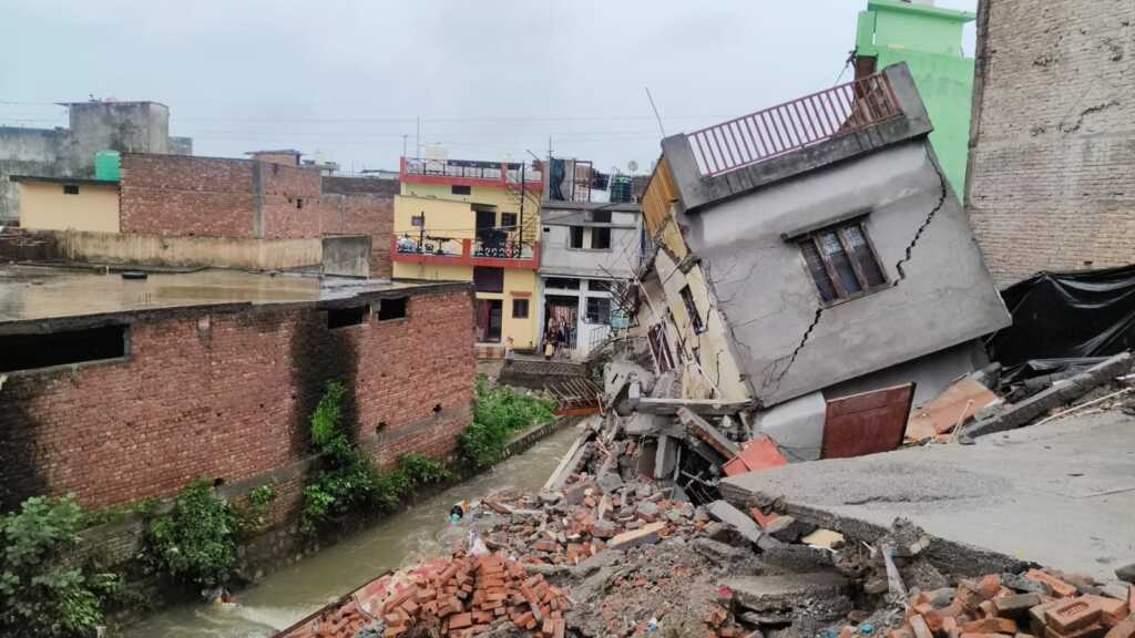 उत्तराखंड में भारी बरसात के कारण कारगी ग्रांट क्षेत्र में नदी किनारे बने दो मकान गिरे, पुलिस तथा फायर सर्विस की टीमों द्वारा तत्काल मौके पर पहुंचकर चलाया बचाव कार्य